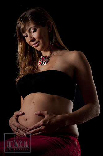 Kvinde der holder sine haender paaa sin gravide mave