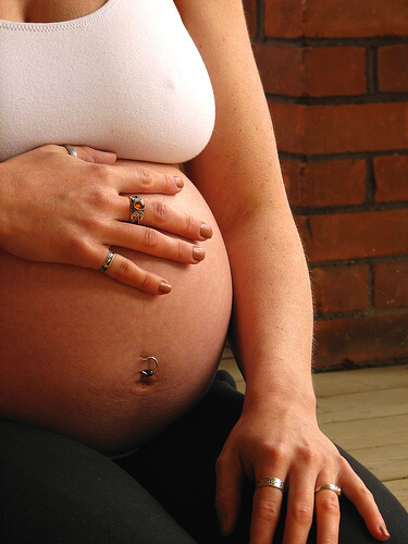 Kvinde med haand paa sin gravide mave