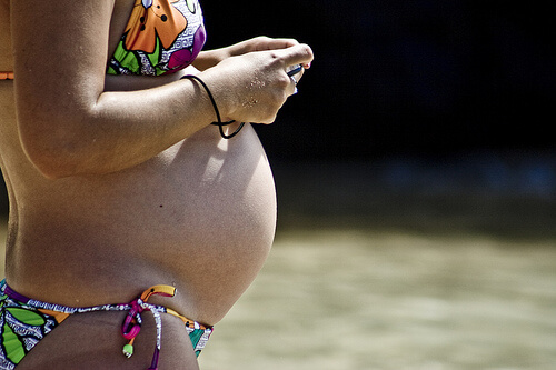 Kvinde der er gravid i bikini