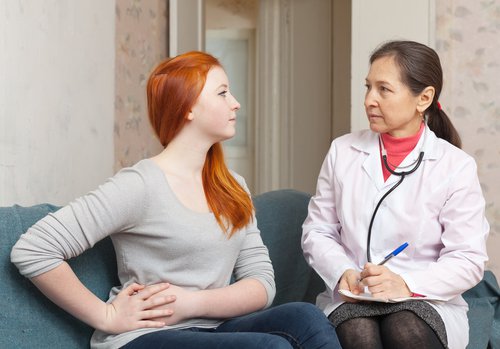 Kvinde snakker med sin læge om mavesmerter.