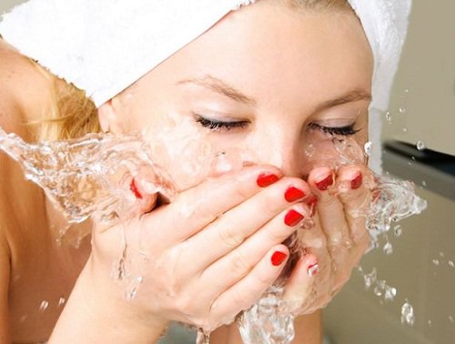 Kvinde der vasker ansigtet