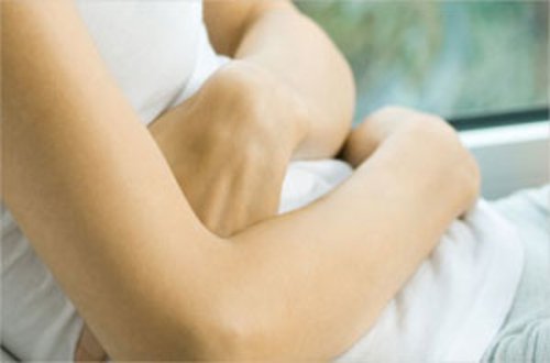 Kvinde der holder sig for maven - inflammation og gigt