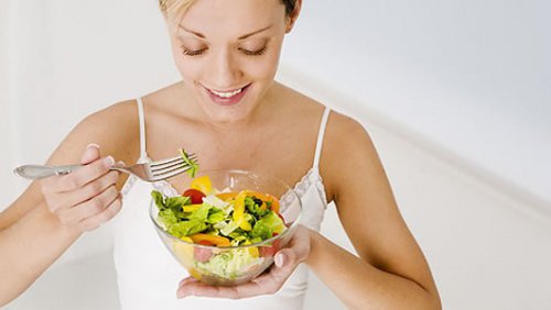 Kvinde der spiser en salat