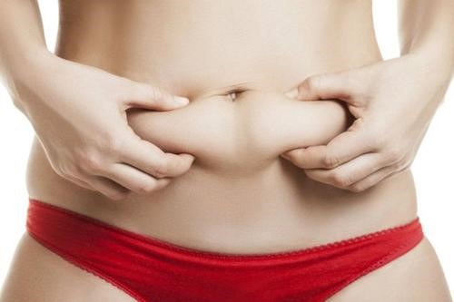 Kvinde der tager fat paa mavefedtet