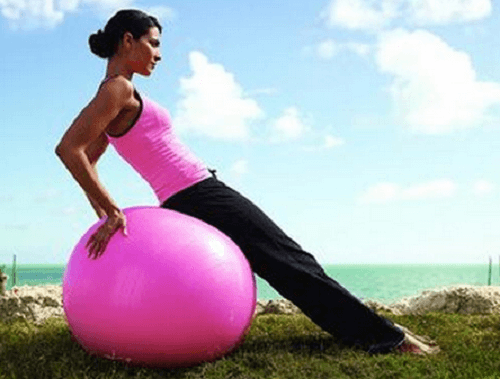 Kvinde der bruger en traeningsbold