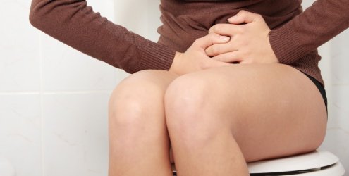 Kvinde der sidder paa toilettet