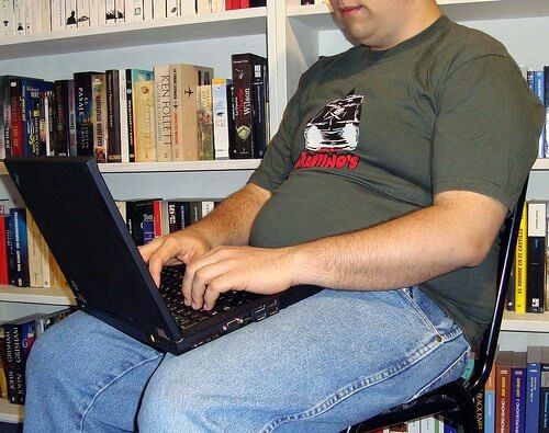 Person der sidder paa en stol med sin computer