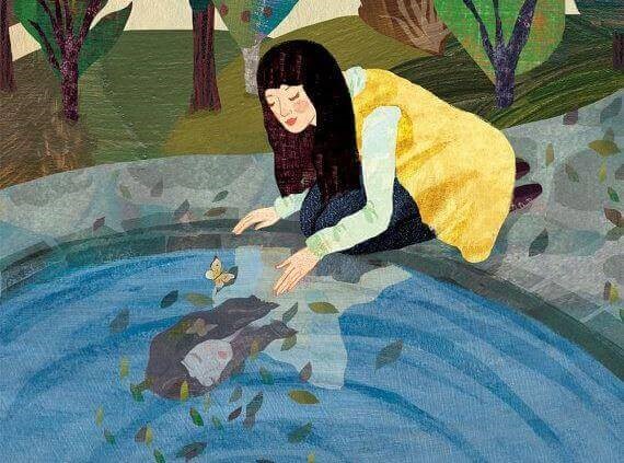 Kvinde der ser hendes spejlbillede i vand