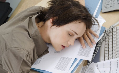 Kvinde der sover paa arbejdet