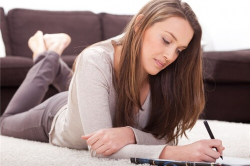 Kvinde der ligger ned og skriver