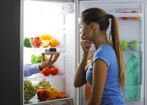 Kvinde der kigger fristet ind i koeleskabet