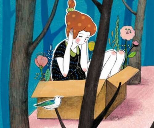 Kvinde der sidder i en papkasse