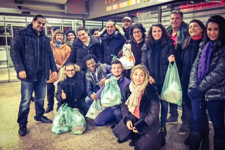 Mange mennesker med poser med varer - madspild i supermarkeder