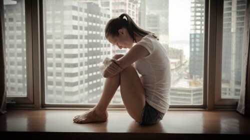 Kvinde sidder og er trist - Foele sig modloes