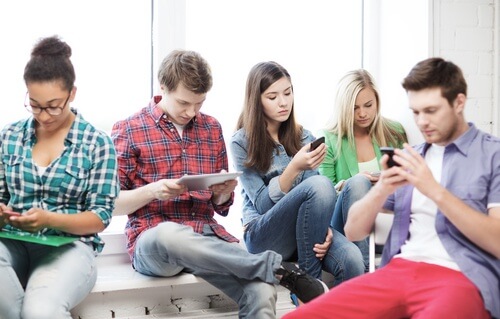 Gruppe unge mennesker der er afhængig af gadgets