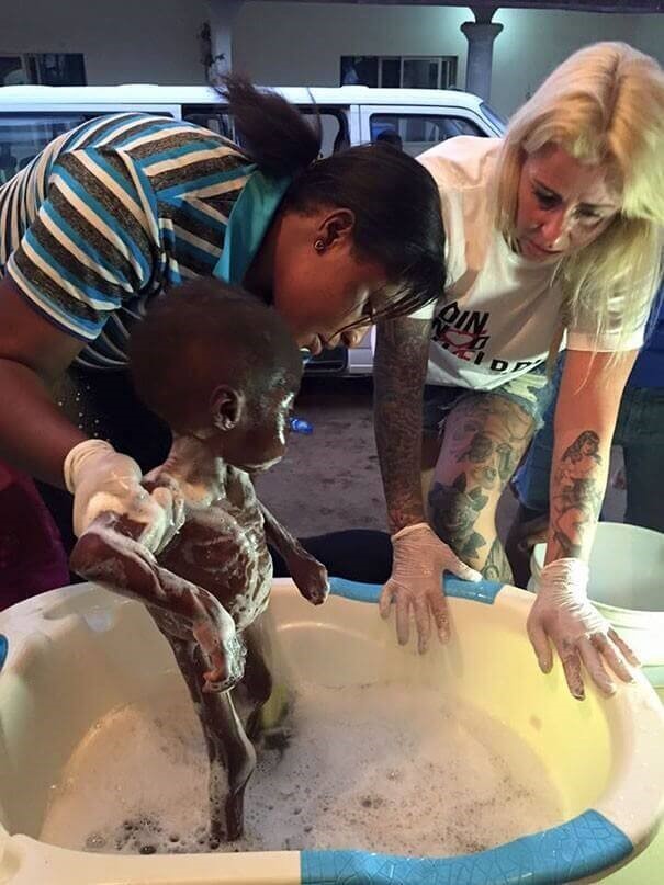 Afrikansk barn der faar et bad