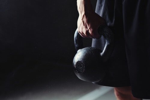 Mand der staar med en kettlebell