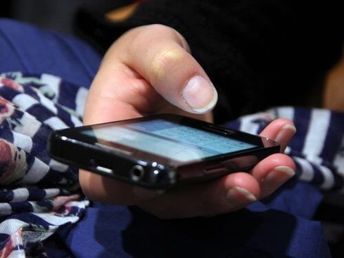 Person der sidder med en mobil