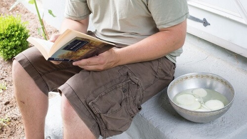 Mand der sidder og laeser med en skaal med loeg