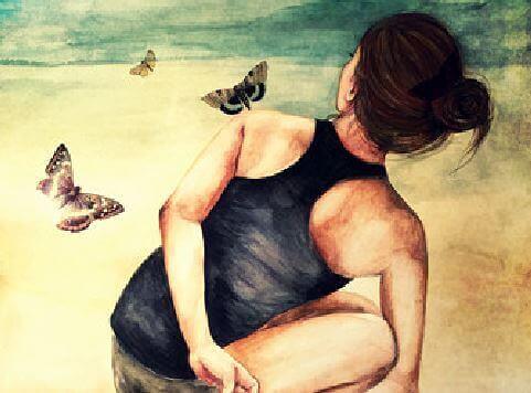 Kvinde der sidder med sommerfugle