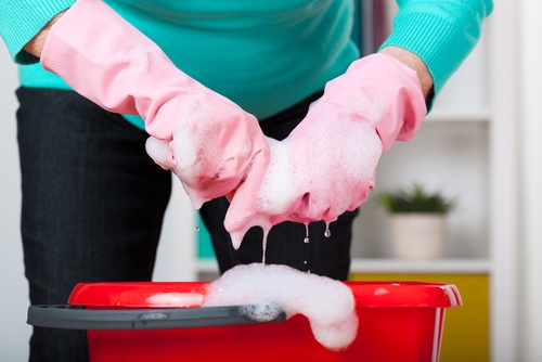 Kvinde der vasker toej med handsker