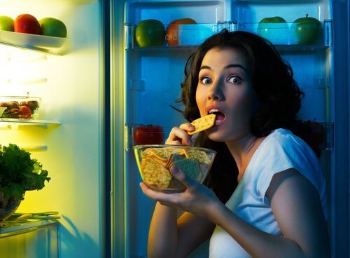 Kvinde der snacker fra koeleskabet