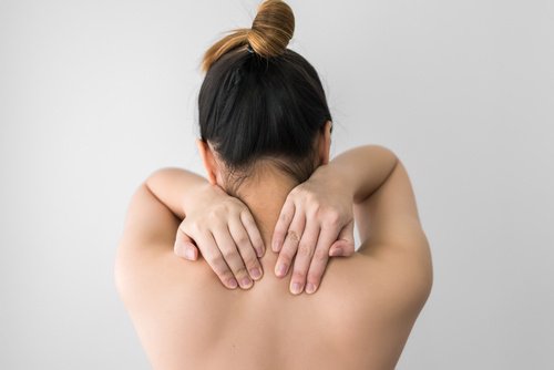 Kvinde med muskelsmerter i ryggen