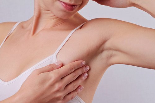 Kvinde der roerer ved sin armhule