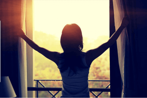 Kvinde der traekker gardiner fra