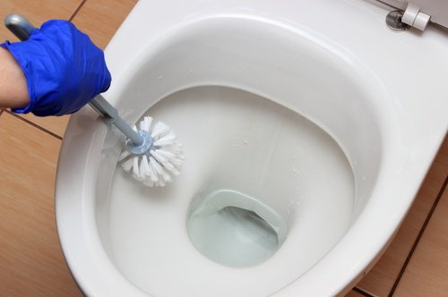 Person er i gang med at rengøre toilet med bagepulver