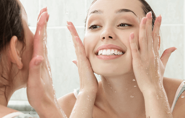 Kvinde der hydrerer sit ansigt