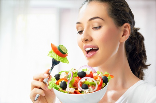 Kvinde der spiser salat - tid til at traene