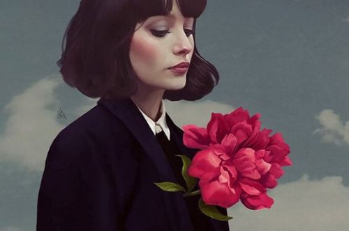 Kvinde der kigger ned paa en blomst