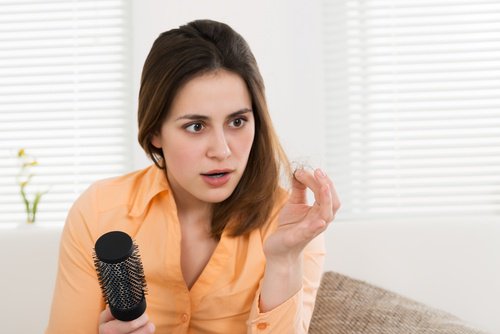 Kvinde der kigger paa sit haar