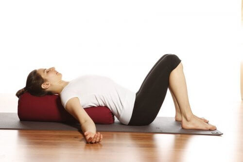 Kvinde der ligger paa en yoga maatte