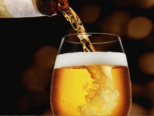 Glas med oel der bliver skaenket op