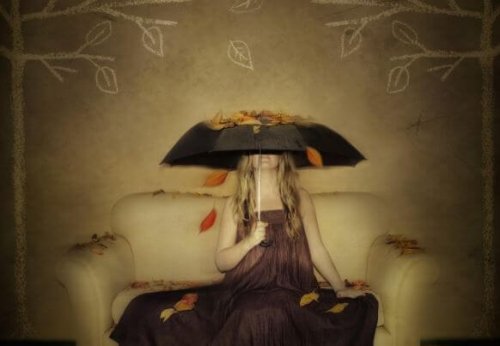 Kvinde der sidder under en paraply