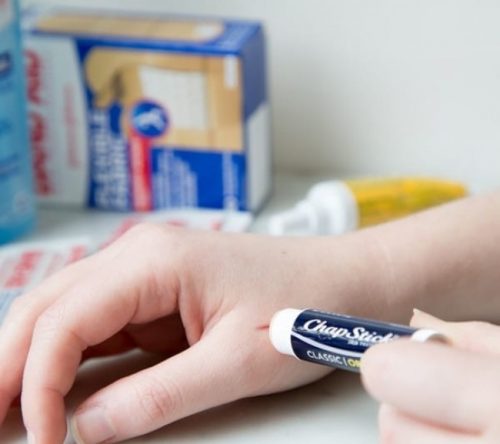 Person kommer laebepomade paa et snitsaar