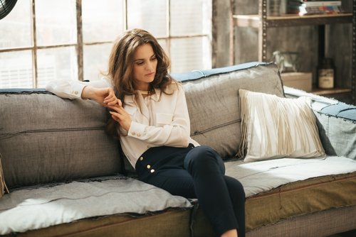 Kvinde der sidder i sofaen