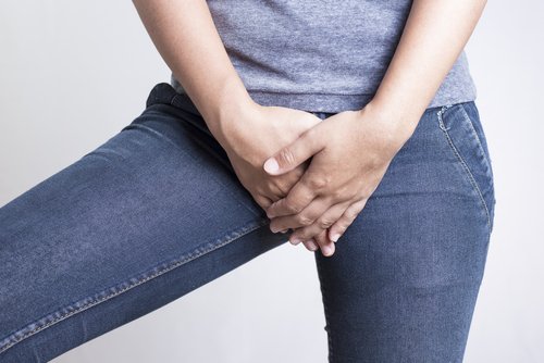 Kvinde der holder sig for skridtet