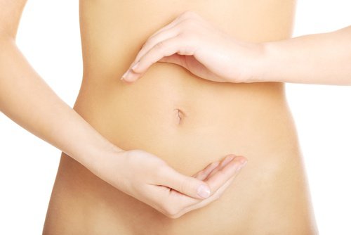 Kvinde der holder sine haender omkring maven