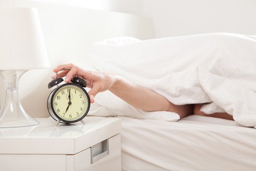Person raekker ud efter vaekkeur fra seng
