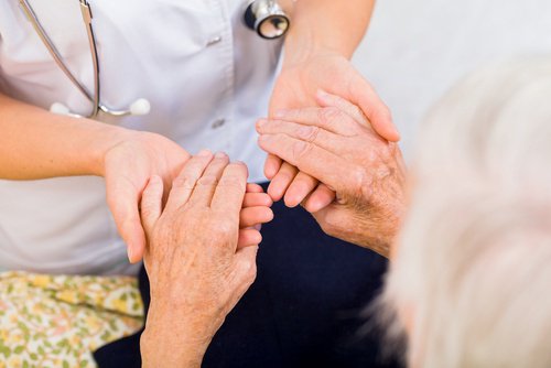 Aeldre kvinde holder laege i haenderne