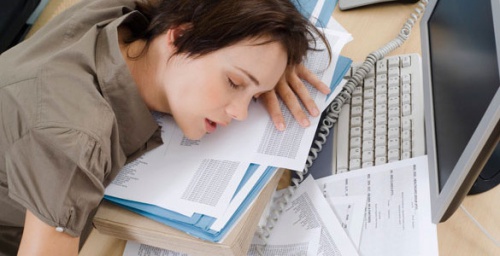 Kvinde der sover paa arbejdet