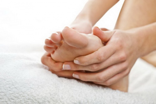 Person masserer sine fødder. 