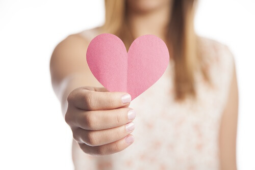 Kvinde der staar med et papir hjerte