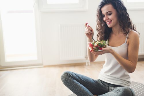 Slank kvinde spiser salat