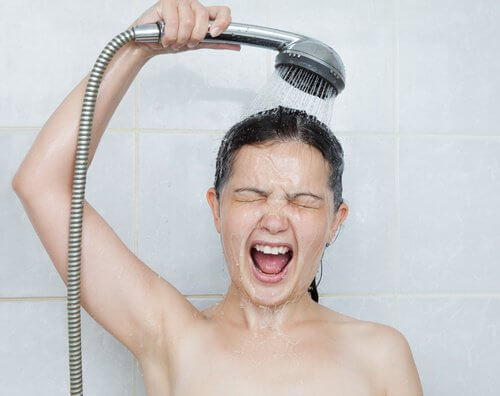 Kvinde der tager et koldt brusebad