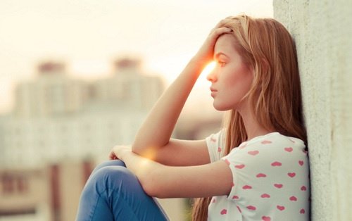 Kvinde tager sig til sit hoved