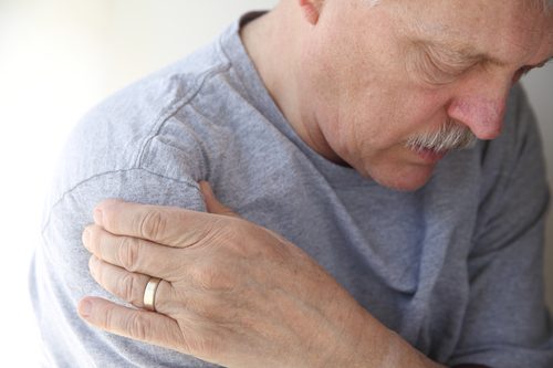 Mand holder sig til sin arm